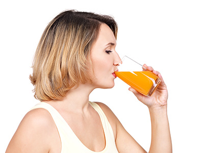 mujer bebiendo zumo de naranja
